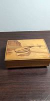 closed music box top showing marquetry seascape design