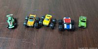 All five toy vehicles lined up on tabletop