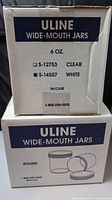 front of two sealed Uline cases labelled 6 oz wide-mouth jars