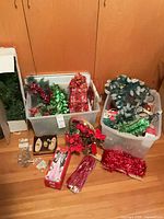 Overall view of two bins with assorted decorations, tinsel, lights and boxed ornaments