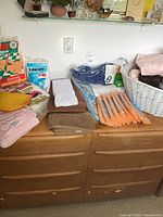 All items laid out: orange brushes, cloth packs, towel stacks, wicker basket
