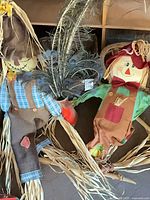 Two fabric scarecrows with feather stems