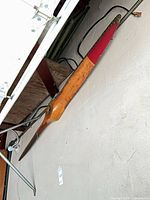 Wooden aircraft propeller mounted on wall, natural wood, red tip, center hub visible