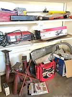 Group shot of charger, vacuum box, jack stands, jump starter and hand tools