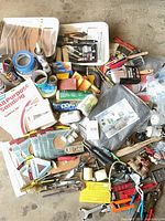 Overview of lot showing paint tray with tools, sanding sheets, tapes, hand tools, plumbing fittings