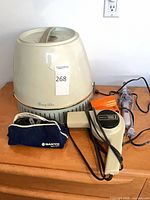 Overall view of all three items: Lady Schick hood dryer unit, Norelco handheld dryer, Sanyo shaver pouch