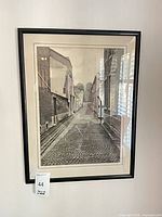 Framed street scene print in black frame with mat