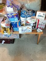 Full group of assorted toilet paper, paper towels and napkins on a bench