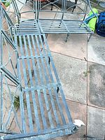 Overhead view showing two sections of the cast metal patio bench with slatted seats and aged patina
