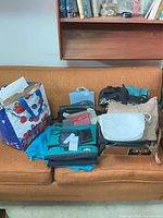 Overall view of assorted handbags and purses on couch