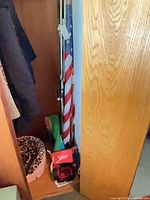 Overall closet view showing jump starter, first aid kit, flag, umbrellas, pet bed