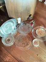 Overview of all glass platters, bowls and porcelain saucers on wooden floor