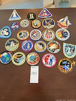 Tabletop layout of 22 NASA embroidered mission patches