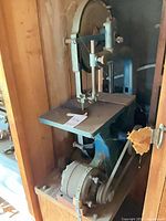 Full view of saw showing upper wheel, table and frame