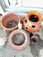 Group view of four terracotta planters showing shapes and sizes