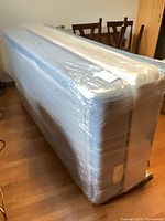 Mattress and box spring wrapped together in plastic