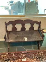 Front view of bench showing design, rush seat, wear