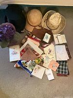 Overview of lot showing three hats, gloves, scarves/handkerchiefs and stack of ephemera