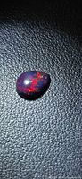 Pear cabochon opal showing red play-of-color