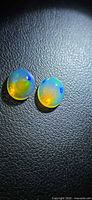 Pair of round-to-oval jelly opals showing colour play