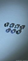 Seven loose Tanzanite gemstones arranged in two rows
