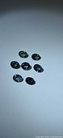 Seven oval sapphires grouped on white background