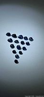 Group of 15 loose deep blue faceted sapphires arranged in triangle