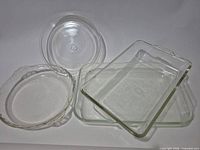 Four clear glass dishes arrayed: two rectangular, two round