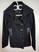 Front view of black jacket on hanger