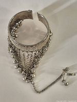 Full view of cuff bracelet showing attached chain and ring