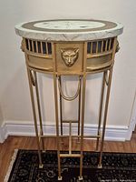 Full view of gold metal table with faux marble top