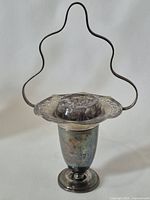 Full view of silver-plated pedestal vase with handle-shaped armature