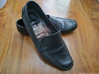 Full view of both shoes on wooden floor