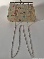 Full view of clutch handbag with chain attached