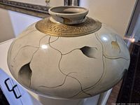 Top view showing neck opening, raised gilt band, painted motifs