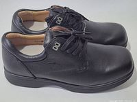Side view of both shoes showing leather uppers and lace-up design