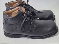 Side view of both black shoes showing uppers and lacing
