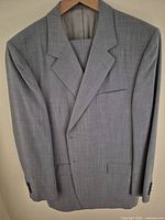 Full view of grey Italian suit jacket with trousers folded inside