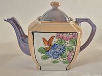 Full view painted ceramic teapot front and side