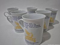 Six white Pegasus porcelain mugs front view