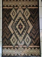 Full view of woven geometric rug showing colors and pattern