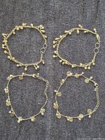 Four bracelets shown; two styles photographed together on dark fabric background