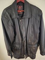 full front view of black leather jacket on hanger