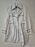 Front view of white trench coat with black piping and tie belt