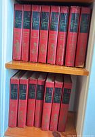 Front view of thirteen red hardcover volumes of The Children’s Hour series arranged on two shelves