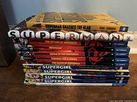 Stacked view showing all visible spines including Superman saga, Superman Smashes the Klan, and four Supergirl volumes