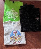 All three Gildan Cartoon Network T-shirts laid flat showing colours and graphics