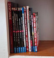 All 12 Harley Quinn graphic novels standing on shelf showing spines