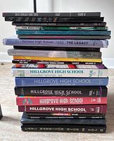 Stack of 19 hardcover yearbooks showing school names and some years/volumes