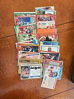Stack and spread of approximately 30 NFL trading cards showing various fronts and backs